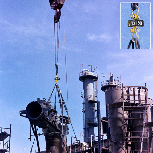 A large steel assembly is lifted into place at a refinery
